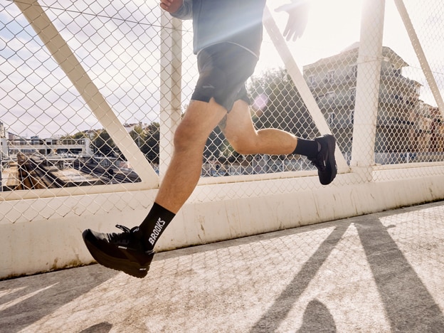 Plano general de una mujer y un hombre con ropa de Brooks Running en una pista rocosa